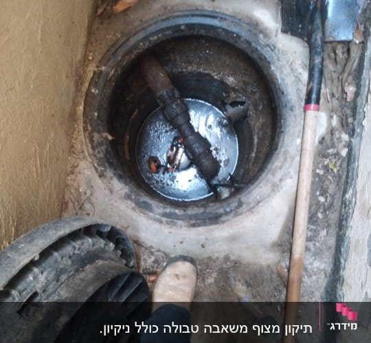 בור ביוב פתוח עם צינור וכלי עבודה